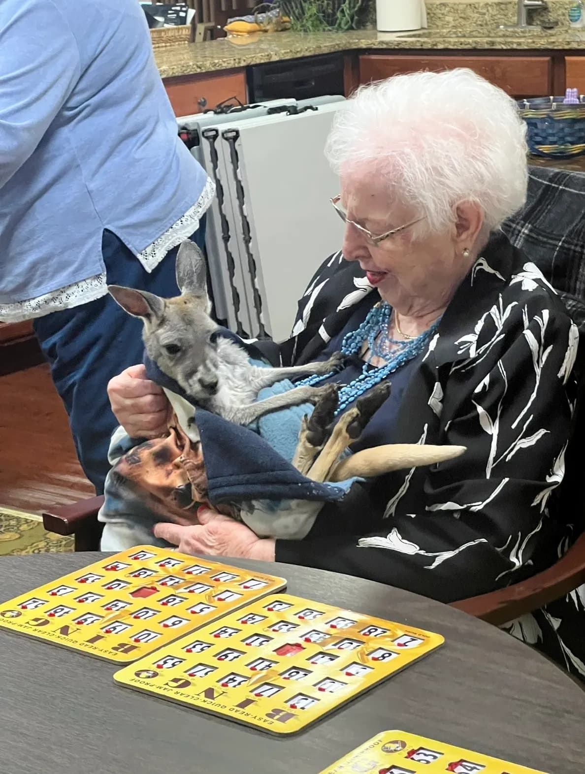 Elderly woman holding Sophie during bingo